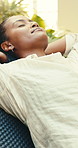 Woman, relax and stretching on chair for holiday, weekend getaway or vacation in luxury retreat. Female person, lens flare or lying with break, rest or stress relief for comfort or accommodation