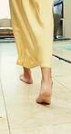 Woman, legs and pool with feet for holiday vacation, weekend getaway or summer travel in resort. Female person, traveler or tourist walking by poolside for break or relaxation in luxury retreat