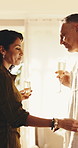 Smile, couple and glass in hotel room with alcohol, arrival gift and celebration for anniversary. Happy, mature people and champagne at resort with embrace, hospitality and romance getaway in bedroom