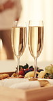 Glass, alcohol and food at hotel with couple, arrival gift and complimentary treat for celebration. People, embrace and champagne at resort with charcuterie board, guest welcome and anniversary date