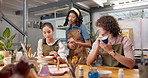 Pottery, instructor and people in class with advice, brushstroke guidance and painting technique. Potter, discussion and teaching in studio for ceramics workshop, creative tips or feedback on artwork