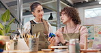 Potter, man and painting in class with clay, sculpture and custom design of handmade craft. People, talking or pottery in workshop with paint brush, artistic process and creative art for diy creation