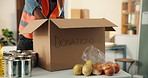 Hands, volunteer and unpacking box of donations, food drive and non profit for charity outreach. Person, stock and collection in cardboard with groceries, pantry goods and package for poverty relief