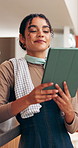 Woman, owner and reading at cafe with tablet, research and inventory management for menu update. Thinking, person or smile at coffee shop with tech, stock checklist and increase price for hospitality
