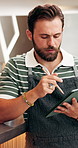 Man, owner and review at cafe with tablet, research and inventory management for menu update. Person, reading and stylus at coffee shop with tech, stock checklist and increase price for hospitality