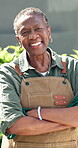 Face, gardening and old woman in home backyard for green thumb, maintenance or eco friendly hobby. Black person, arms crossed and garden outdoor for landscaping, planting and wellness in retirement