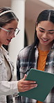 Happy, students and talk at university with tablet, online learning platform and sign up for course. Women, smile and discussion outdoor at college with tech, higher education or research for degree.