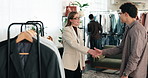 Fashion, handshake and smile with customer in boutique, shopping and consultation for outfit choice. Happy people, shaking hands and assistance for client, discussion and clothing decision in store