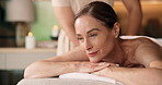 Spa, back massage and woman with smile, luxury and comfortable on holiday and stress free on break. Resort, hospitality and happy mature person on vacation, thinking and relief for muscle tension