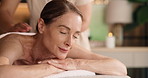 Woman, relax or massage with masseuse in spa for physical therapy, healing or body treatment. Comfort, female person or customer lying with smile on table for stress relief, holiday or pamper session