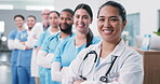 Doctor, face and medical team with arms crossed for leadership, primary health and about us pride. Hospital staff, woman or happy in hallway for patient care, service integrity or healthcare in line