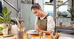 Pottery, woman and painting ceramic in workshop for merchandise, creative and small business. Happy person, startup shop and handmade craft store for manufacturing, productivity or artist pride