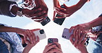 Outdoor, hands and friends with phone for connection, online community or typing text in circle. Low angle, group and people with mobile for communication, smile and laugh with social media app