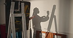 Shadow, woman and painting in workshop with canvas, drawing and art creation for gallery showcase. Female person, artist or sketch in studio with paint brush, artistic process and artwork masterpiece