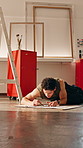 Creative, man and drawing in art studio with pencil, illustration talent and craft for stress relief. Artist, person relax and sketch on floor with DIY creation, design skills and tools for project.