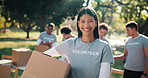 Woman, volunteer and face in nature with box, campaign or happy for community outreach program. NGO, humanitarian or team in park for food drive, social responsibility or donation project for charity