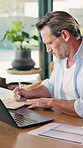 Laptop, man and writing notes for remote work with insurance, research or thinking in home office. Computer, mature freelancer and person with notebook, policy risk assessment or problem solving