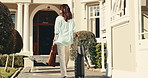 Woman, travel and walking with suitcase for holiday getaway, weekend stay or vacation in hotel. Back view, female person or traveler with bags for accommodation in luxury retreat, estate or resort