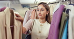 Shopping, smile and woman in store with clothing rack, outfit search and decision in trendy style. Retail, happy and customer in boutique with apparel, garment choice or option for fashion purchase.