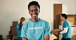 Happy man, volunteer and face in NGO with arms crossed, community service and outreach program. Coordinator, confident and laugh at centre for food drive, social responsibility or project about us
