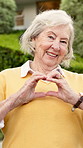 House, face and old woman in front yard with heart hands, buy property and wellness for retirement. Happy, senior person outdoor and moving in new home with love emoji, good mood and real estate.