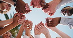 People, unity or holding hands together with group for social cohesion, inclusion or solidarity. Low angle, team or community with connection, support or trust for outdoor synergy or collaboration