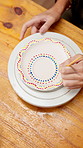 Hands, person and painting pottery for art in studio, creative decoration and handmade craft. Paintbrush, pattern or potter with ceramic in workshop for design inspiration, artistic process and above