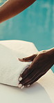 Woman, hands and masseuse with towel in spa for holiday relaxation, getaway or stress relief. Female person, therapist or beauty salon with fabric or cloth by swimming pool for zen or massage prep