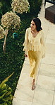 Above, woman and walking at resort for travel, guest arrival and checkin for summer holiday. Thinking, smile and mature person at hotel for tourism, explore villa and destination for vacation rental