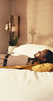 Tired, woman and relax in hotel room with bed, comfortable and exhaustion from international travel. Tourist, person and jet lag fatigue in lodge with overseas vacation, peace and relief for arrival.