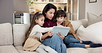 Ebook, tablet and mother reading to children on sofa in living room together for bonding or break. Digital, storytelling app and woman with sibling kids in family home for development or learning