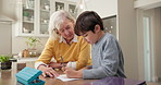 Grandmother, child and help with homework, school assessment and learning for development. Family, home and boy with senior woman for answer, studying and support for education, knowledge and growth