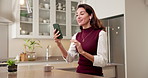 Happy, woman and video call with phone in kitchen for conversation, discussion or online meeting. Female person, user or talking with smile, earphones or technology for friendly chat or app in home