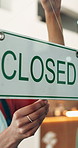 Woman, hands and window in cafe with closed sign, hospitality or end of day notice at small business. Waitress, person and glass door in coffee shop with board, poster and message for diner closure.