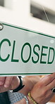 Hands, owner and closed sign at cafe, shift change and temporary closure for private reservation. Man, entrepreneur and signage at coffee shop with notice, trading hours and storefront for booking