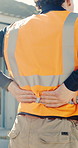Man, hands and back pain on construction site with injury, building accident and massage for relief. Hurt, person and builder outdoor with muscle inflammation, fatigue and overworked from project.