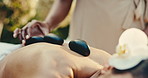Spa, spine and woman with hot stones for back massage, muscle tension and stress relief at resort. Hospitality, hands and person with heat therapy for holistic healing, pamper wellness and self care