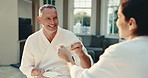 Cheers, man or couple in spa with coffee, bonding trip or anniversary celebration in wellness center. Happy, love and mature people with drink, connection and romantic moment on peaceful honeymoon.