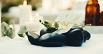 Flowers, stones and spa for relax, aromatherapy candle and natural wellness for stress relief. Basalt rocks, resort or orchids for therapy with calm, peace or holistic healing at luxury salon for zen