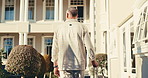 Back, man and arrival at hotel with suitcase, check in and accommodation for holiday abroad. Thinking, mature person and walk outdoor with luggage, guest service and resort entrance on vacation trip