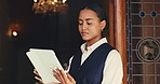 Woman, receptionist and scroll with tablet at front door for hotel, travel or booking accommodation. Lobby, concierge and digital tech for guest, reservation and customer service for hospitality