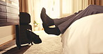 Hotel room, legs and take off shoes for business travel rest, unwind and relief from long journey. Guest, man and remove footwear on bed for work trip checkin, traveler decompress or personal comfort