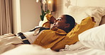 Bed, woman and relax in hotel room with peace, travel exhaustion and thinking of vacation itinerary. Calm, tourist and person rest in accommodation with fatigue, planning and vision for holiday.