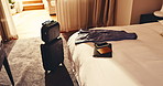 Hotel, travel and suitcase in room with bed, passport and laptop electronics with phone on holiday. Resort, luggage and accommodation interior for hospitality, tourism or motel furniture for vacation