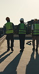 Construction, team and back of people on rooftop for meeting, planning and building project. Architecture, morning and workers in discussion for remodeling, property development and inspection