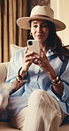 Phone, smile and woman relax in hotel lounge for communication, luxury hospitality or vacation. Mobile, happy mature person and typing for travel, deluxe accommodation and think of text response