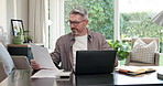 Remote work, paper and man in home office with laptop, forecast and growth plan in finance review. WFH, digital or mature advisor with document, budget outlook or reading report on revenue projection