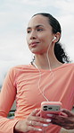 Runner, phone or happy woman with earphones in city on break, browsing playlist or streaming radio. Mobile, fitness podcast or female person with music outdoor, smile or think of audio on internet