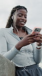 Fitness, phone and happy woman with music in city on break, browsing playlist or streaming radio. Mobile, sports podcast or black person with earphones outdoor, smile or thinking of audio on internet