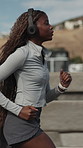 Fitness, woman or running in city with headphones for cardio endurance, workout or track pace. Check watch, black person and runner with music outdoor for training timer, health stats or exercise jog
